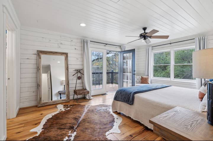 Dormitorio principal con cama tamaño king y vista legítima del amanecer desde la cama. Incluye acceso directo al porche. 