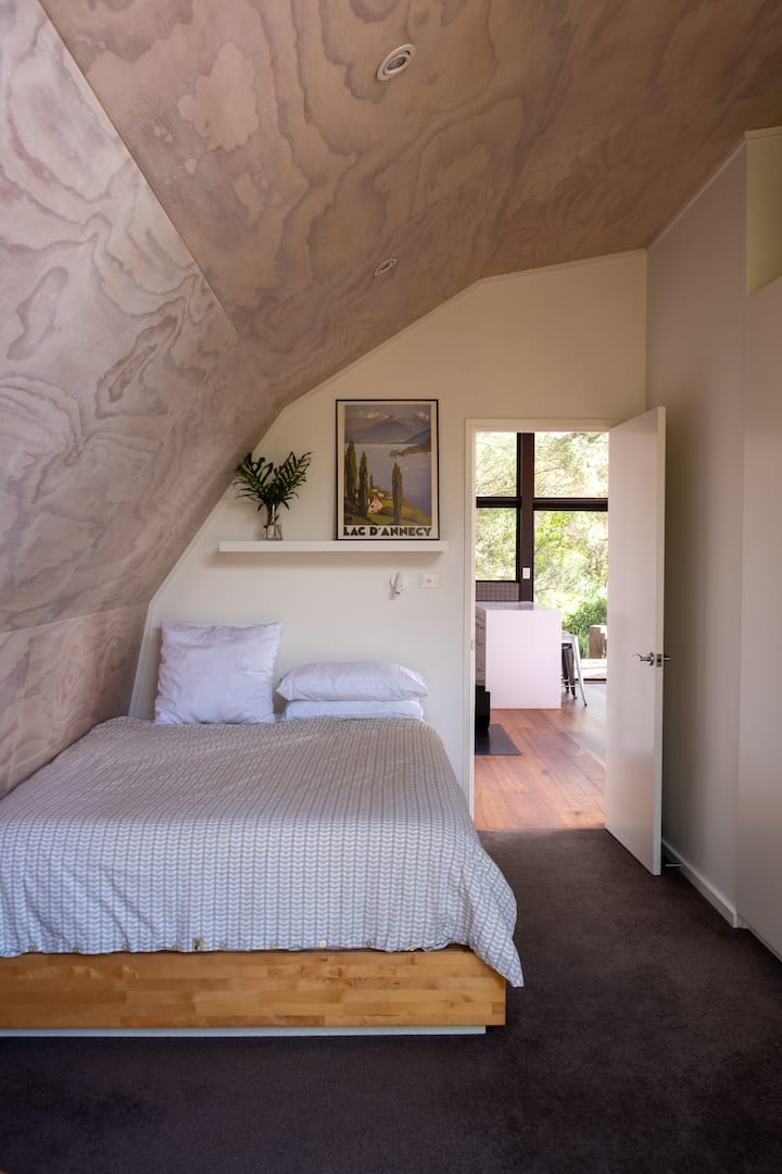 El dormitorio principal tiene una puerta corrediza que da a la terraza envolvente y a las vistas de la vegetación exterior. Ambas habitaciones están equipadas con una unidad de calefacción y refrigeración de ciclo dividido.
