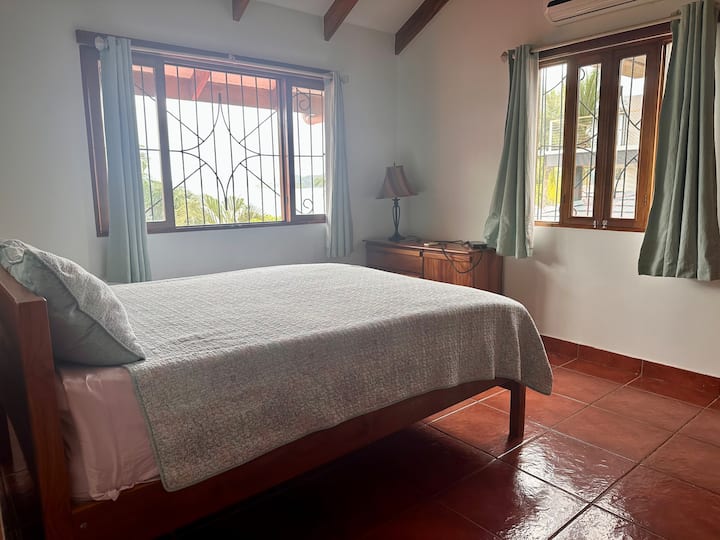 غرفة نوم ثانية في الطابق العلوي مع سرير متوسط الحجم، وتوفر إطلالات على الفناء الخلفي والمسبح والمحيط.