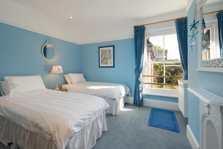 La habitación con dos camas orientada al sur se renovó recientemente. Ahora cuenta con un nuevo lavabo y tocador, así como con una alfombra completamente nueva. Con una decoración en azul claro, tiene un toque marino fresco.