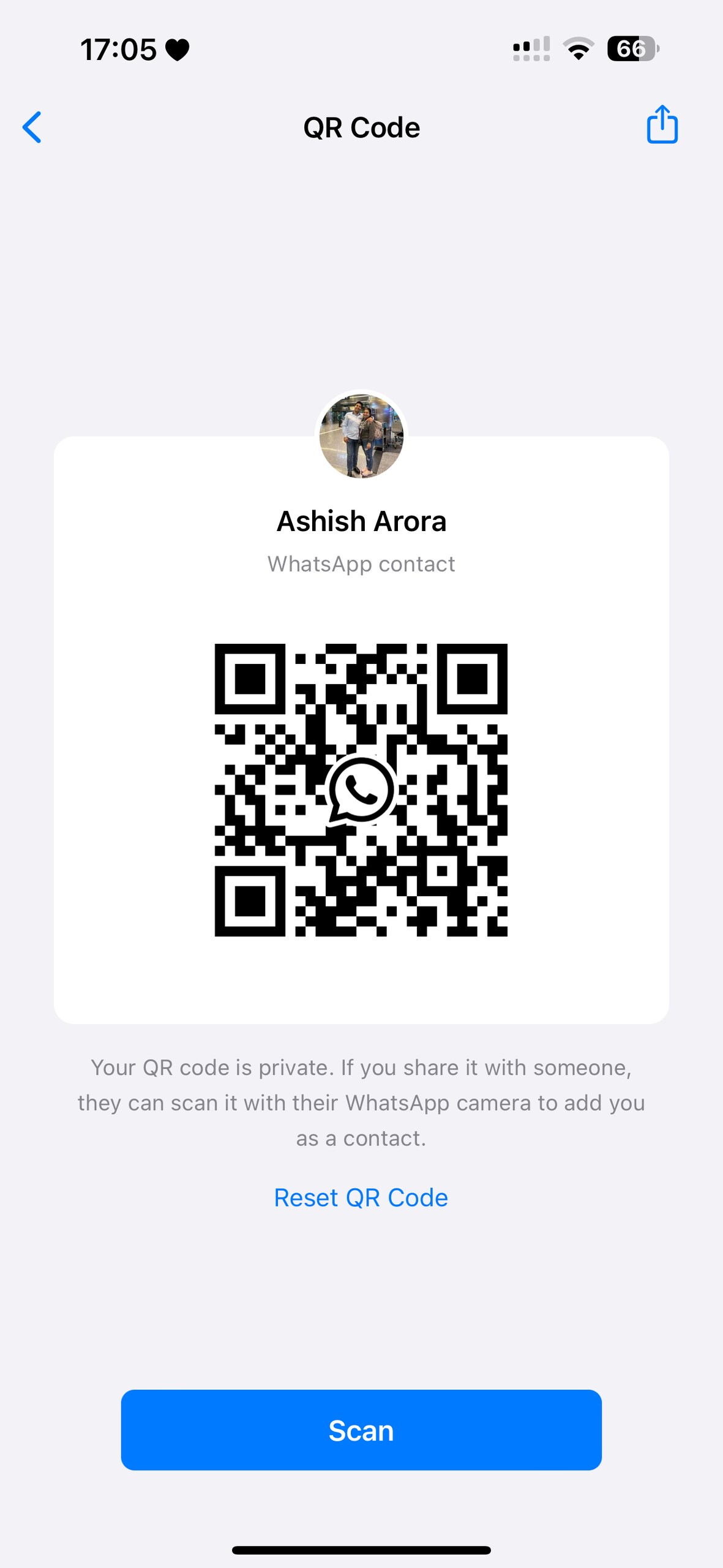 A QR code is displayed on a light background. The code consists of black squares arranged in a unique pattern. At the top, a circular profile picture is visible, showing a group of people. Below the code, the text 'Your code is private' is provided, indicating its usage for adding a WhatsApp contact.
