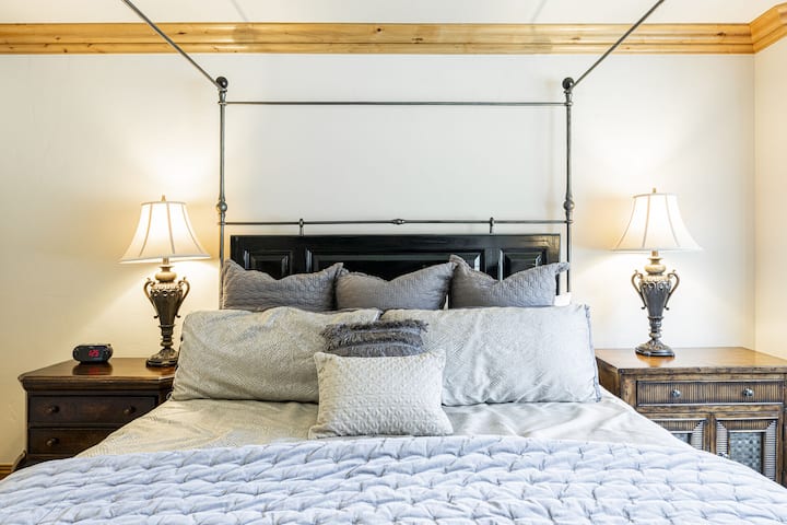 Dormitorio principal con cama tamaño king, TV inteligente, chimenea de gas y baño privado