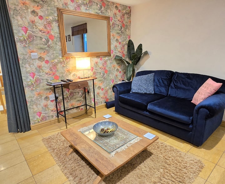 Versatile sofa-bed (small double) with privacy curtain in basement living room. Shower room just down the corridor