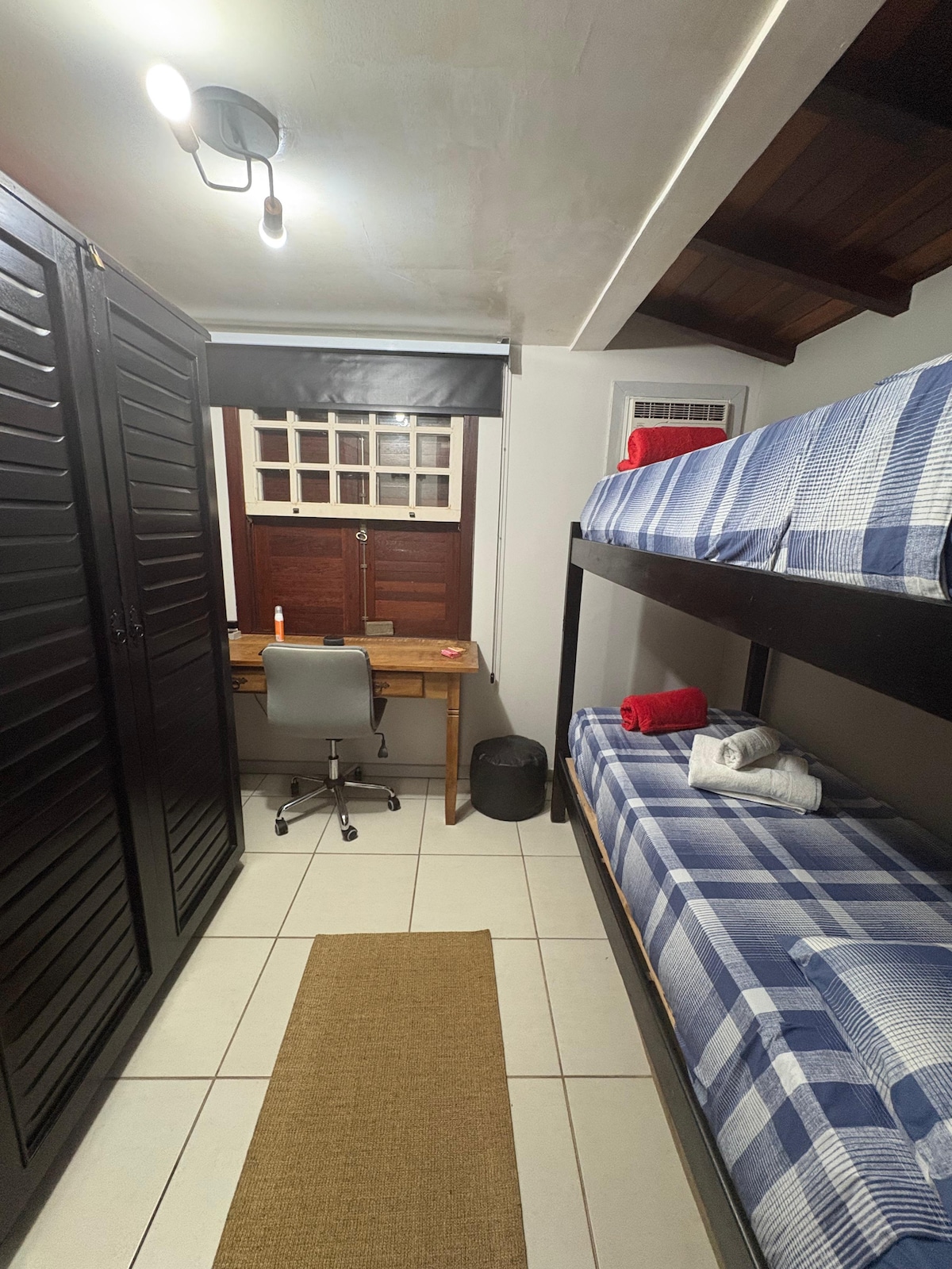 ოთახი ორსართულიანი საწოლითა და სამუშაო მაგიდით.