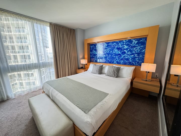 Ფართო საძინებელი დიდი საწოლითა და ბუნებრივი განათებით.