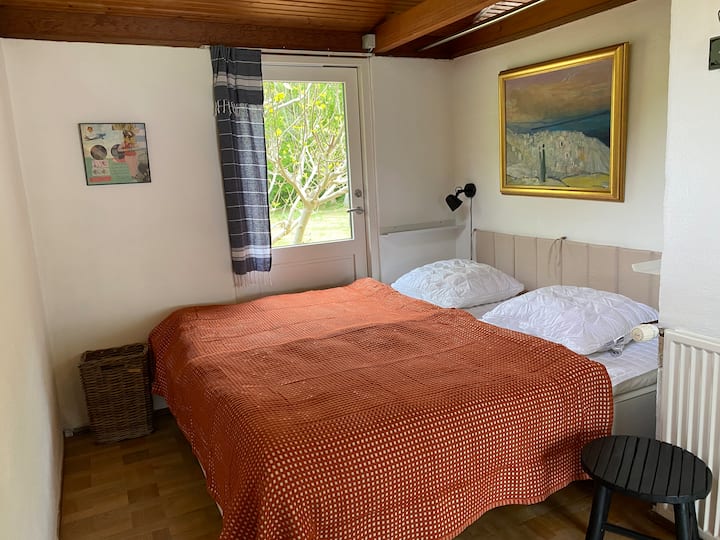 Room 1: Large double bed.  Located unobstructed, separated by door from corridor. The bed has two mattresses, each 90x200 cm. Chest of drawers and a little hanger space. Door to terrace can be opened.