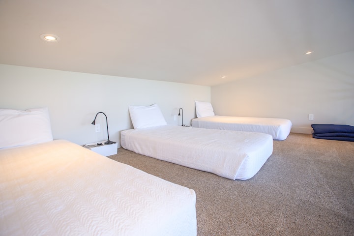 The sleeping loft accessed by a custom ship ladder offers three twin beds. 