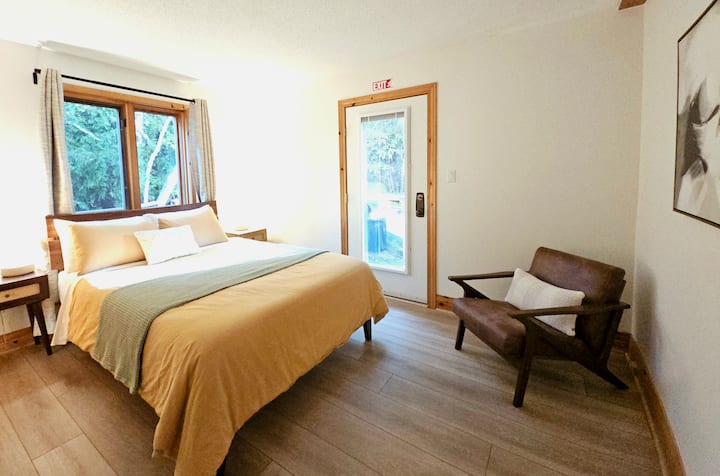 Alba (soft dawn): cozy queen bedroom overlooking green grass and cedar