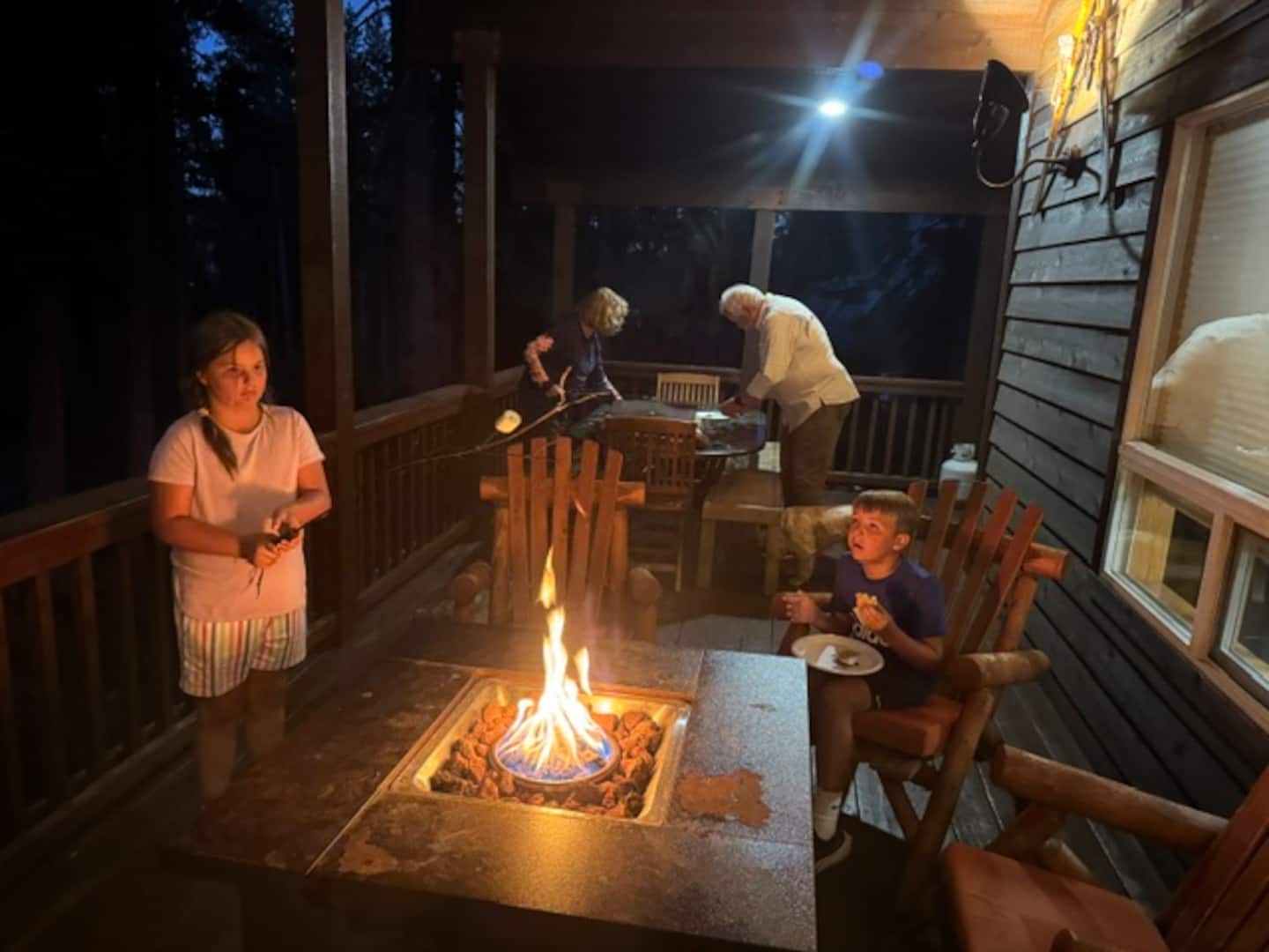 Guests making s'mores at the fire pit on The Lodge deck