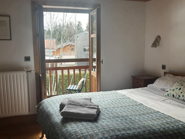 Dormitorio en el primer piso con cama tamaño king, puertas dobles al balcón orientado al sur y baño con ducha y lavabo.  Hay persianas para la noche.