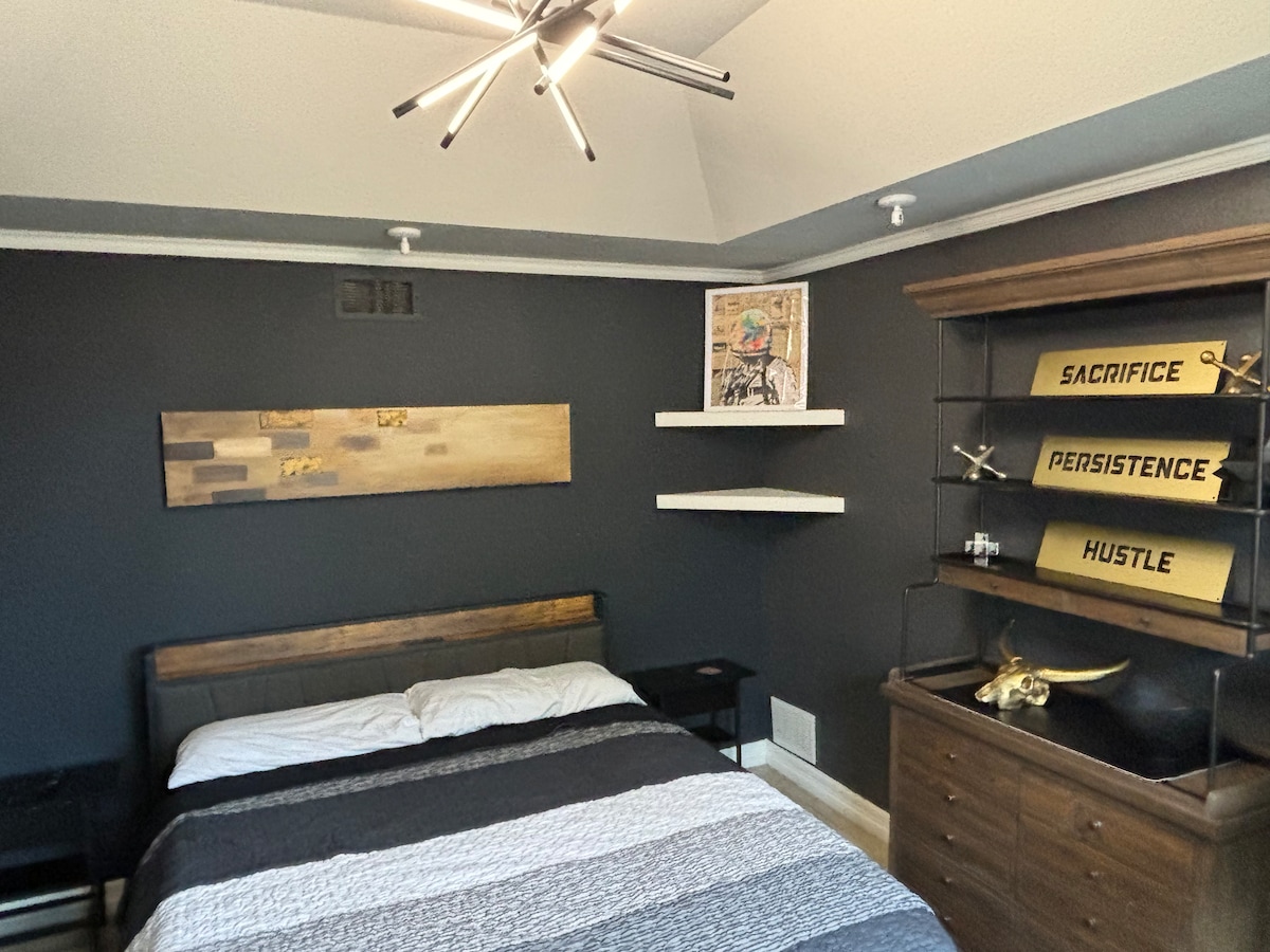 משרד/חדר שינה למטה עם מיטת קינג סייז ושולחן. 