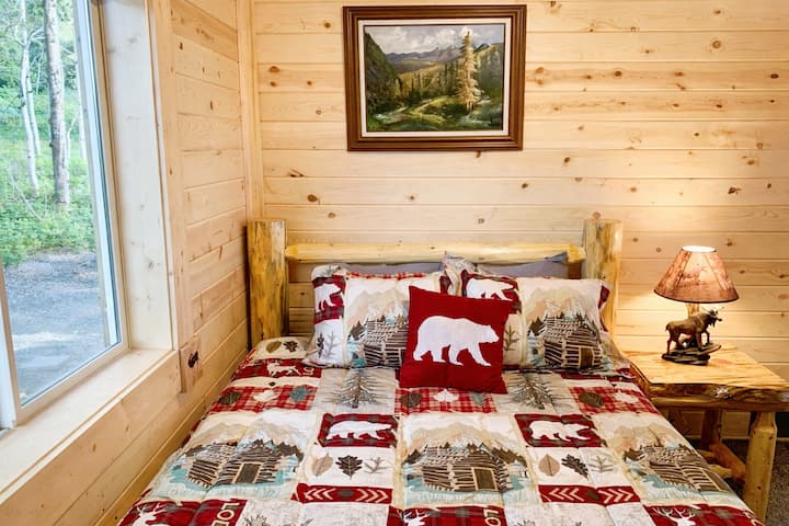 Bedroom 2 downstairs with a queen sized solid pine log bed. 