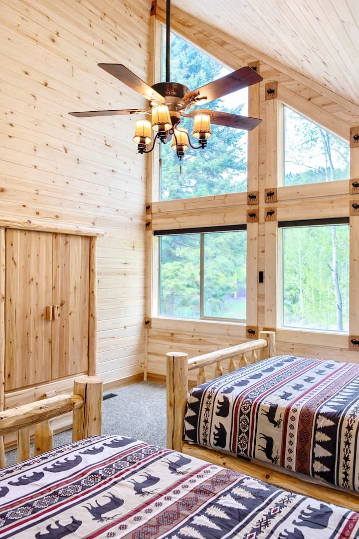 Bedroom 3 upstairs with 2 queen sized log beds. The log beds in this cabin are made from locally sourced lodgepole pines and each piece is peeled by hand. They were sanded, finished and assembled with care by Chris and Sonia!