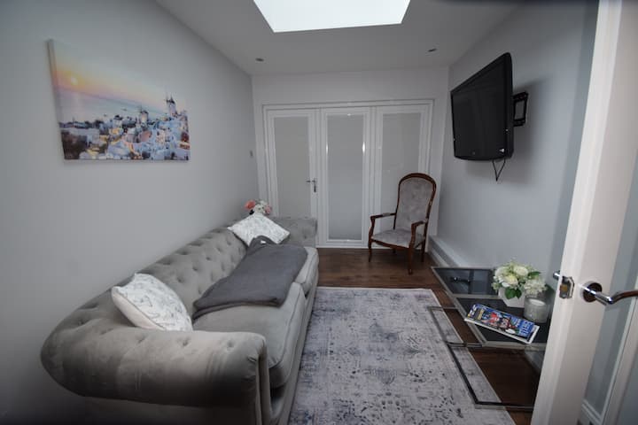Sala de TV que conduce al patio y al jardín