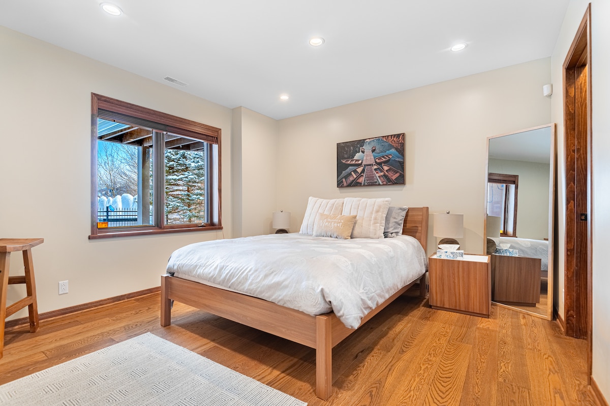 Dormitorio con cama tamaño queen con baño completo en suite y vestidor ubicado en el nivel del jardín  