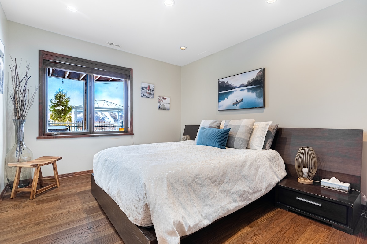 Dormitorio con cama tamaño king ubicado en el nivel del jardín cerca de los dormitorios 5 y 7 y con vistas a Mont Tremblant. 
Baño privado completo y vestidor 