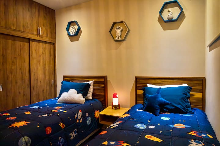 ორიერთი საძინებელი. აქ არის დეკორატიული ლამპა, სამაგიდო თამაშები ბავშვებისთვის და წყლის პისტოლეტები აუზებისთვის.