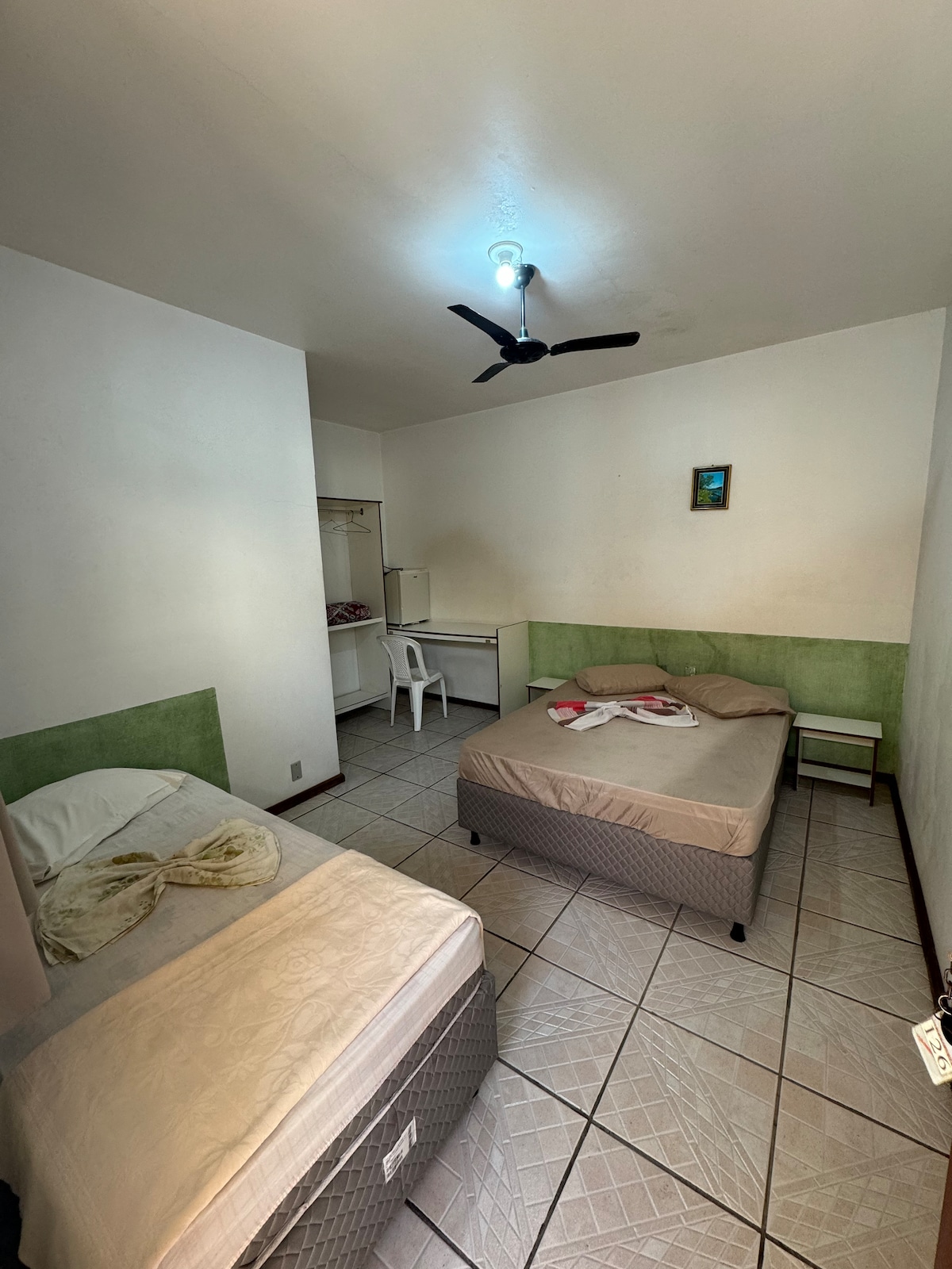 ห้องพักมีม่านบังแสง กระจก โต๊ะข้างเตียง มินิบาร์ พัดลมเพดาน พื้นที่ทำงานพร้อมเก้าอี้พลาสติก ไม้แขวนเสื้อ และที่เก็บเสื้อผ้า เรามีผ้าปูเตียง ผ้าห่มและหมอนให้