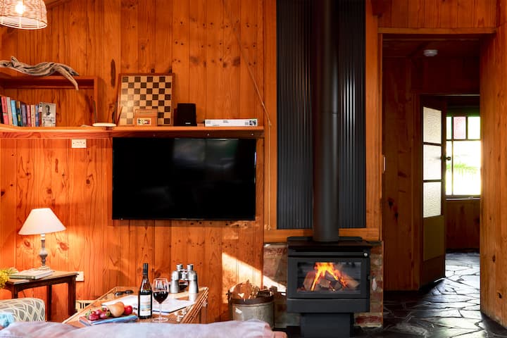 Sainty's Creek Cottage‑ში თქვენ გელით მყუდრო მისაღები ოთახი, რომელიც მოწყობილია ხის ელემენტებით, აქვს სმარტ‑ტელევიზორი და ბუხარი.