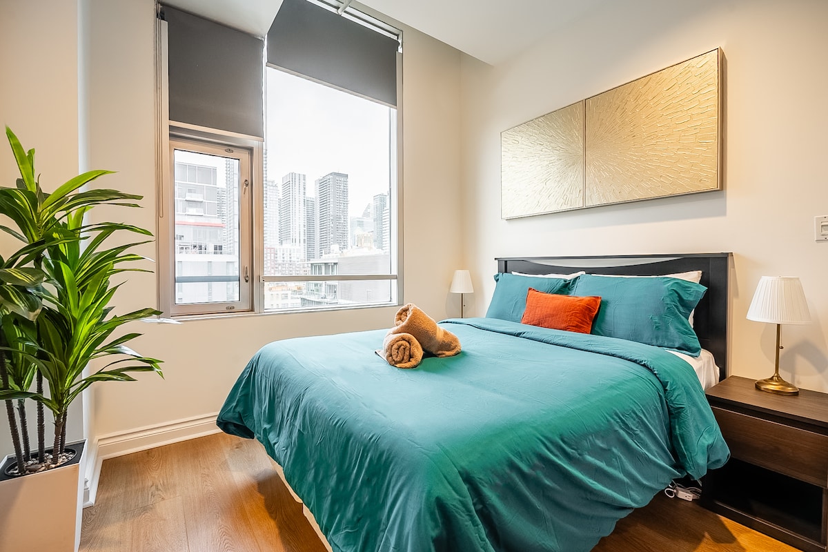 дясна спалня с удобно двойно легло и зашеметяваща гледка към центъра на града.