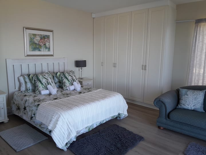 Dhomë gjumi me fotografi 5 kate poshtë (1 krevat dopio "queen"), hapësirë në dollap dhe pamje nga oqeani dhe kopshti.