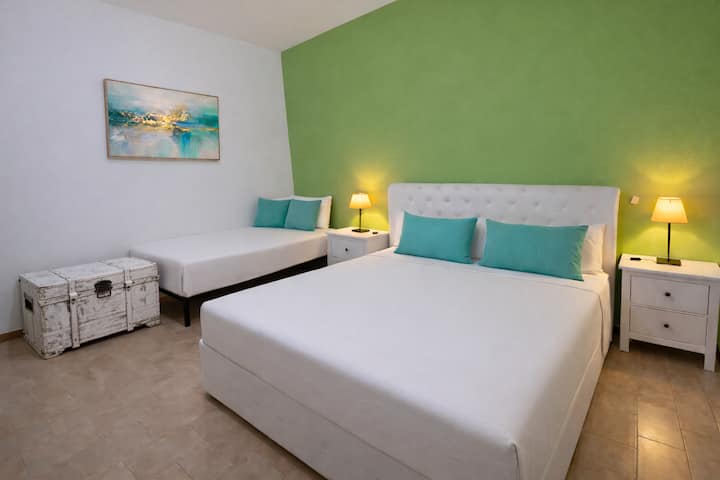 Dormitorio amplio y luminoso con cama matrimonial y una cama individual. Aire acondicionado, ventilador, mosquiteros y juego de sábanas. Todas las habitaciones se limpian cuidadosamente y se desinfectan con vapor a 160° para garantizar la máxima comodidad.