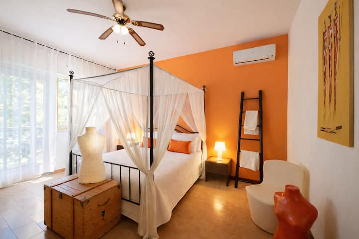 Habitación grande y luminosa con cama con dosel. Equipada con aire acondicionado, ventilador, mosquiteros y un juego de sábanas.  Al atardecer, esta habitación adquiere colores únicos y envolventes. 