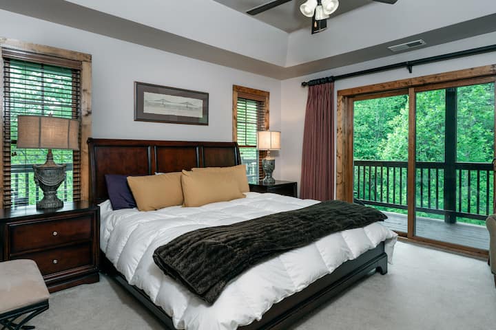 კალიფორნიული სამეფო ზომის საძინებელი ძირითად ნომერში, ტერასაზე გასასვლელით და ნაკადულის ხედით.დიდი ძირითადი აბაზანა მიმაგრებულია.