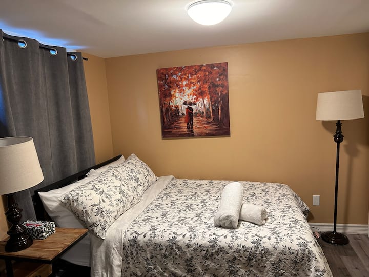 una cama tamaño queen en el piso inferior, conectada a la segunda sala de estar 