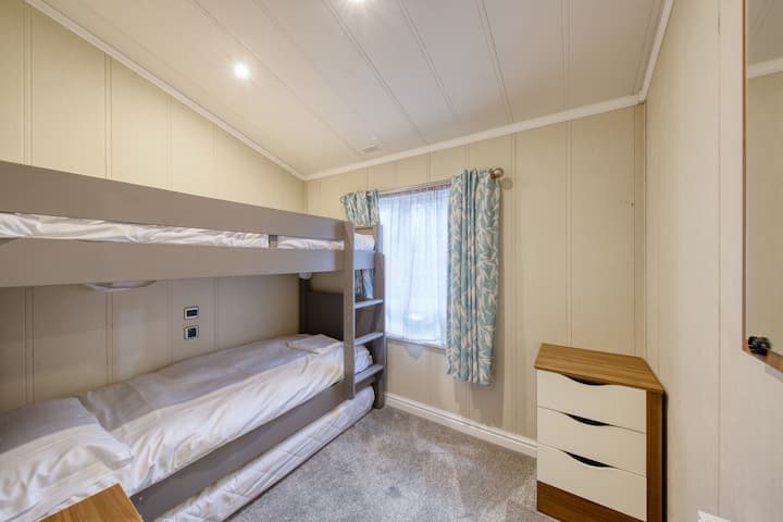 Kitanda cha ghorofa chenye ukubwa wa kawaida pamoja na godoro moja ambalo linaweza kuvutwa kutoka chini.