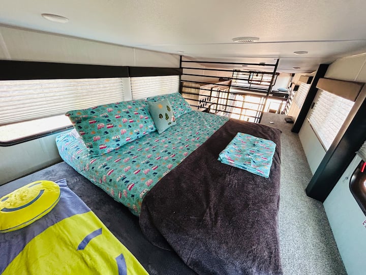 Dormitorio loft para autocaravanas con cama tamaño king, pequeño mate junto a él para persona adicional o niño y chimenea eléctrica. 