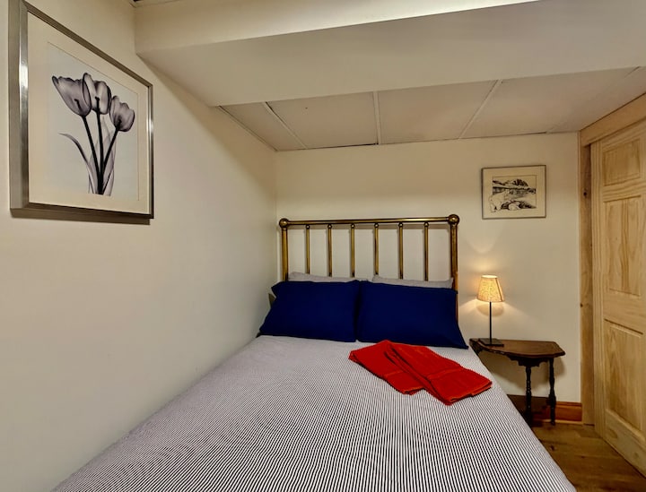 Chumba cha kulala cha ghorofa ya chini 5: Kitanda cha shaba cha kale, kifua cha droo, meza ya kando ya kitanda.