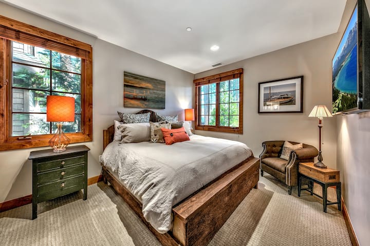 Relájate en tu tranquila recámara con detalles rústicos de madera, lujosa ropa de cama y un acogedor sillón de lectura junto a ventanas llenas de luz natural.