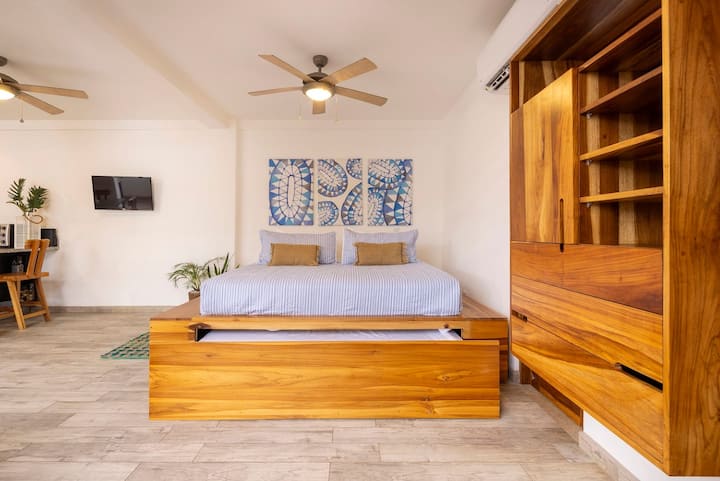 Zona de dormitorio diseñada para un sueño reparador y una relajación total. Cuenta con una cama tamaño king de madera de teca maciza hecha a mano con una conveniente cama nido extraíble de tamaño completo para que duerman hasta 4 personas adicionales. Disfruta de aire acondicionado dividido y un ventilador de techo.