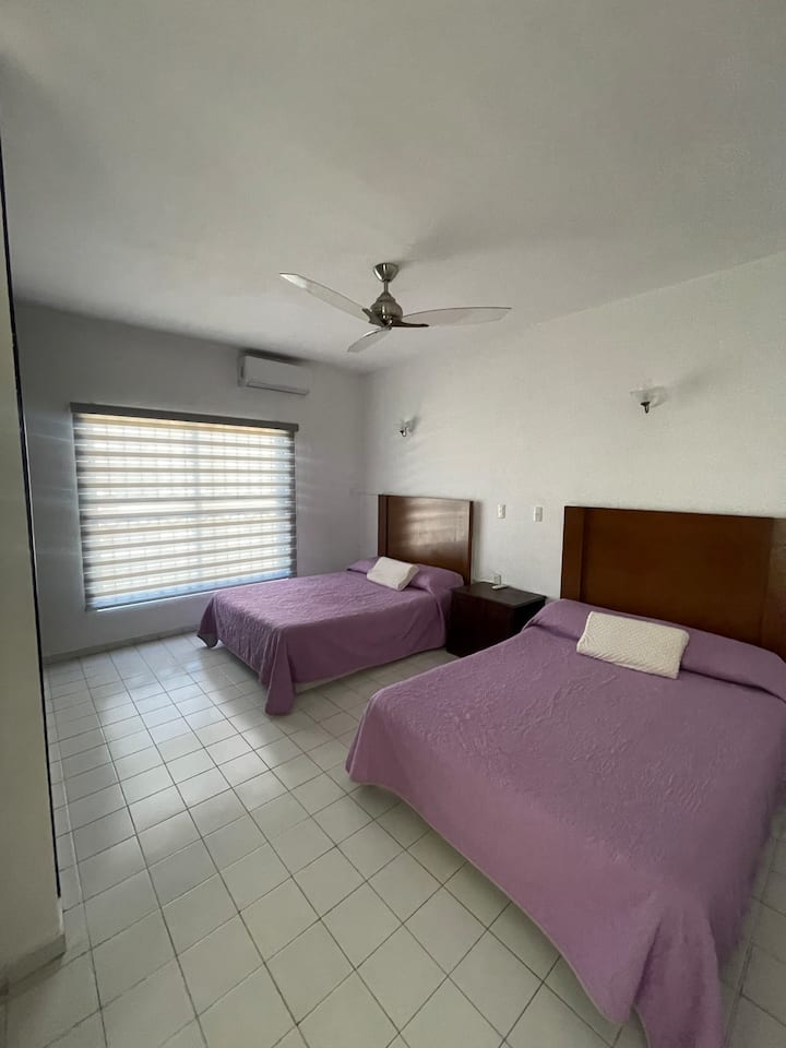 Recámara con baño con dos camas matrimoniales y baño compartido