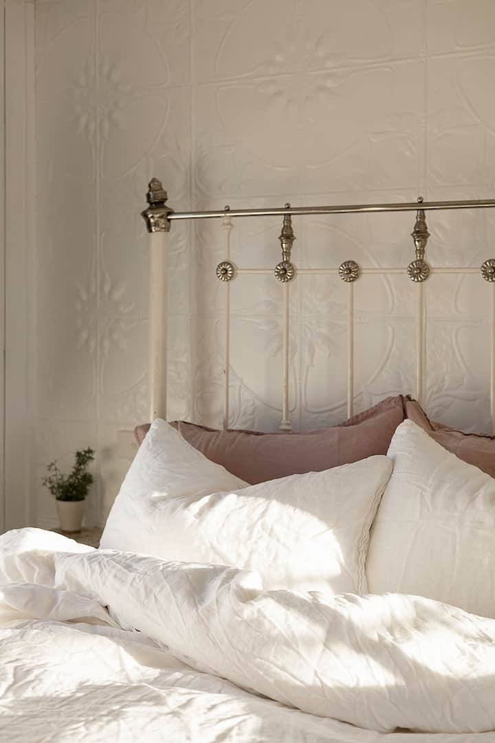 Soft linens and an iron cast bed frame. 