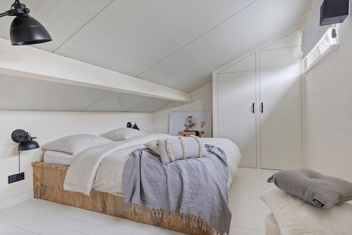 Dit is de slaapkamer op de eerste verdieping; bereikbaar via de slaapkamer beneden. Een kledingkast met ruimte om te hangen en te leggen. Stijlvol ingericht met zacht bedlinnen. 