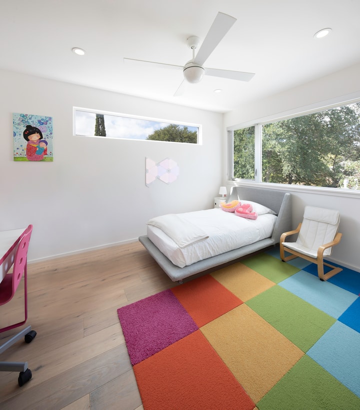 Arriba, tercera habitación de invitados con cama de tamaño completo, escritorio para trabajar a distancia y mucha luz solar. 