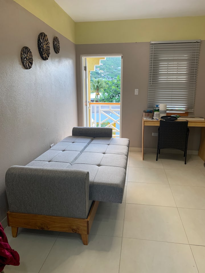 Sofá cama, escritorio de oficina y silla en la sala de estar