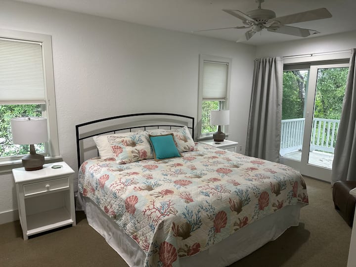 חדר השינה בקומה השנייה כולל מיטת קינג סייז, פינת ישיבה ומרפסת משותפת מחוברת.