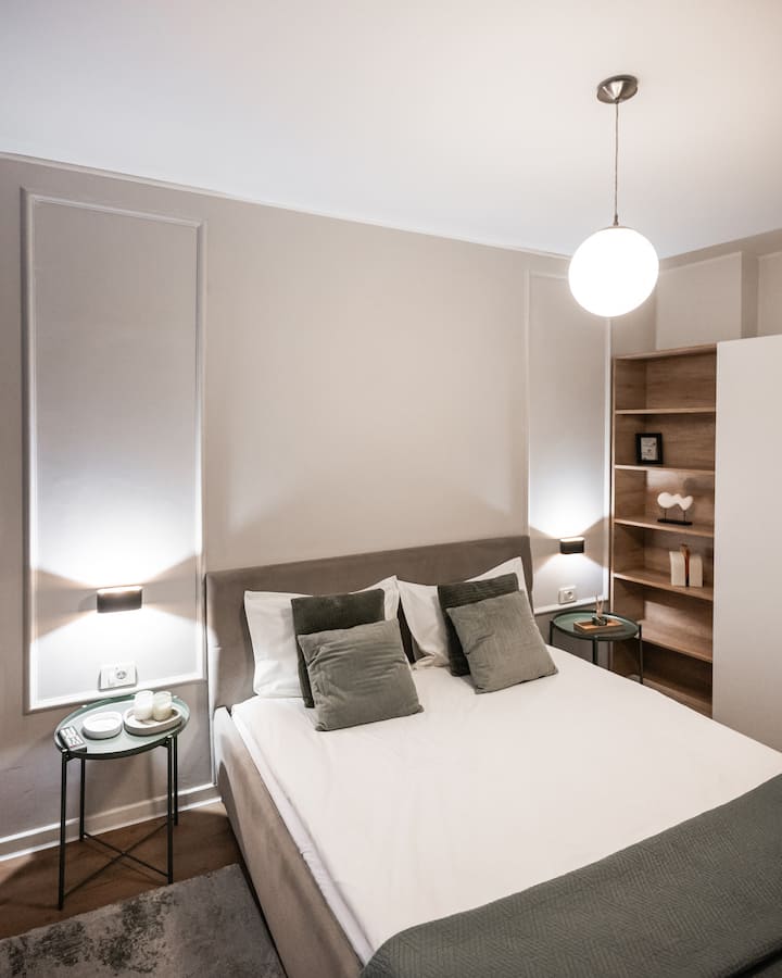 Elegantna i prostrana glavna spavaća soba s velikim bračnim krevetom i velikim prostorom za odlaganje. Moderan dizajn s vrhunskim završnim obradama, koji nudi mir i udobnost potrebnu za luksuzan odmor u središtu Brašova. Klima-uređaj