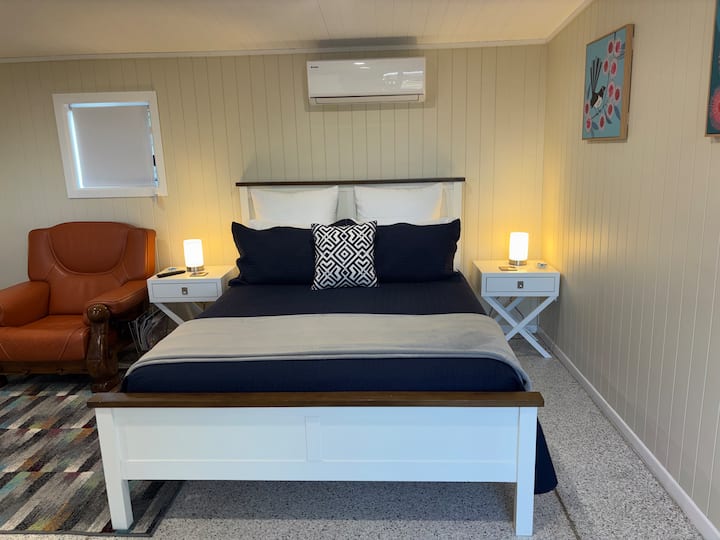 Queen bed with side tables and armchair