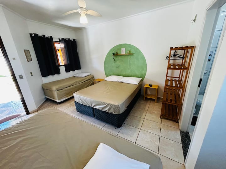 Quarto com 1 cama de casal padrão, 1 cama de solteiro tamanho padrão e 1 cama de solteiro king (solteirão). TV, ventilador de teto + ventilador de bancada e frigobar