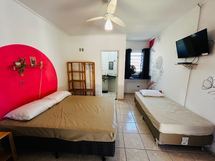 Quarto com 1 cama de casal padrão, 1 cama de solteiro tamanho padrão e 1 cama de solteiro king (solteirão). TV, ventilador de teto + ventilador de bancada. Este quarto não possui frigobar. 