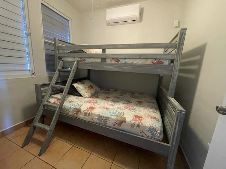 Una litera, llena en la parte inferior y dos camas individuales en la parte superior