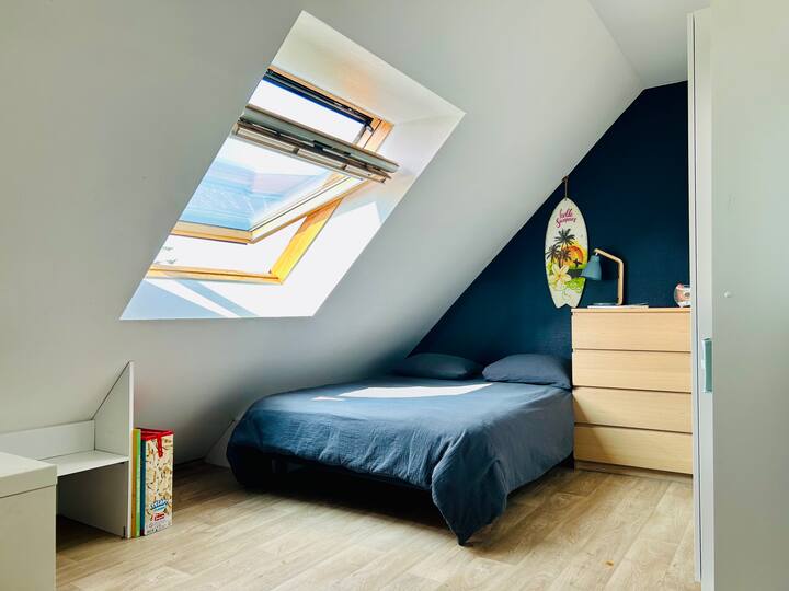 Habitación abuhardillada luminosa, cama doble, zona de despacho, biblioteca. Fresco en verano gracias al aire acondicionado en la entreplanta contigua.