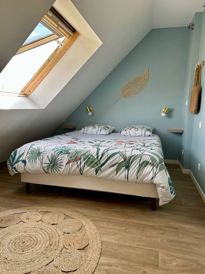 Habitación luminosa abuhardillada con cómoda cama queen size, TV de pared, almacenamiento. Ambiente tranquilo y acogedor.

Fresco en verano gracias al aire acondicionado en la entreplanta contigua.