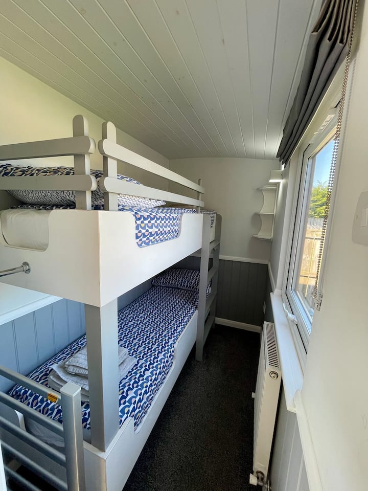 Children’s bedroom comprising bunk beds (only suitable for children) clothes hanging space and clothes hangers.