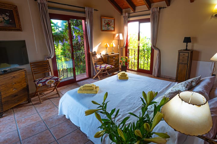 חדר עם מיטה זוגית בגודל 180 על 200 ס”מ וחדר רחצה פרטי.