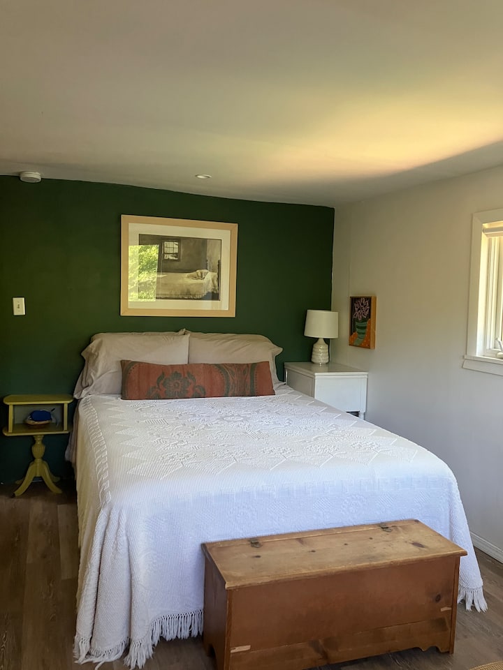 舒适的主卧室设有一张标准双人床和一扇面向水的窗户。 